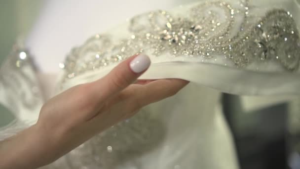 The bride holds a wedding dress in her hands — Stock Video