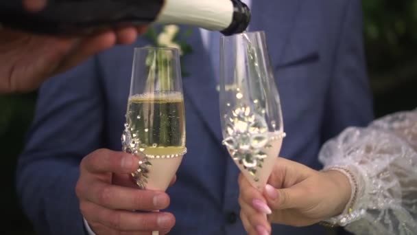 A man and a woman pour champagne into glasses — Vídeos de Stock