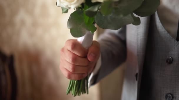Bruidsboeket in de handen van de bruidegom — Stockvideo