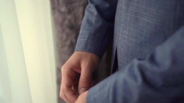 Um homem aperta as mangas em seu casaco — Vídeo de Stock