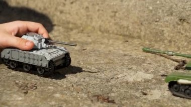 Bebek küçük oyuncak tanklarıyla oynuyor