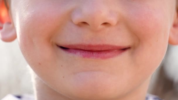 Un niño sonríe con una sonrisa sin dientes — Vídeo de stock