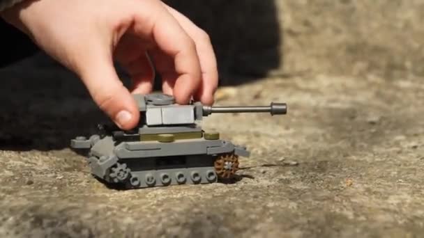 Baby playing with toy tank on the street — Wideo stockowe