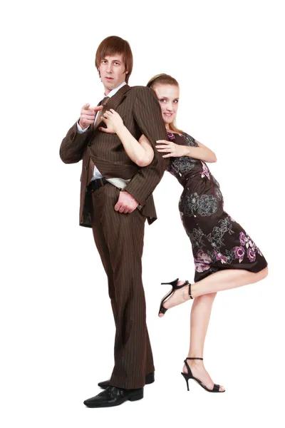 Привлекательный молодой человек в коричневом костюме и красивая блондинка в стильном шелковом платье, держась за руку — стоковое фото