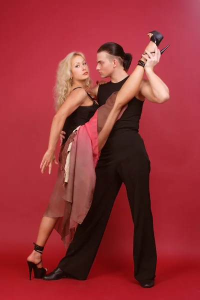 Belle blonde et brunet dansant tango sur fond rouge — Photo