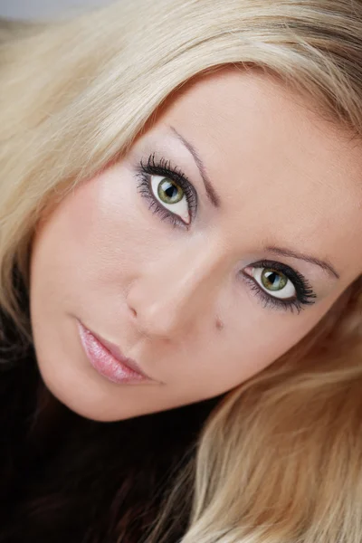 Close-up portrait of beautiful blond woman with professional smoky eyes makeup — Stock Photo, Image