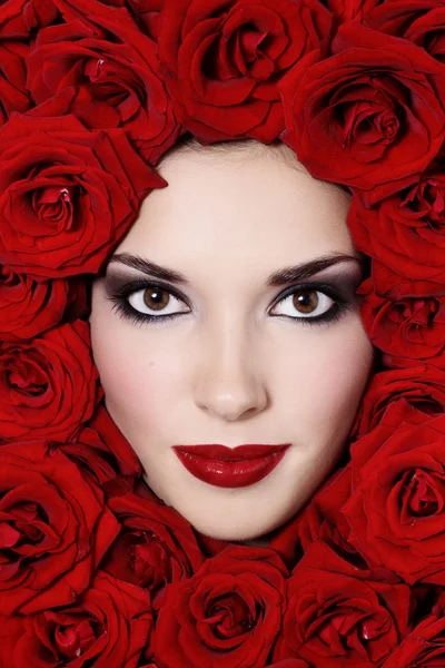 Девушка в красных розах — стоковое фото