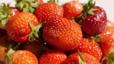 Erkek eli, yeşil yapraklı sulu kırmızı çilek alır.