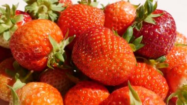 Erkek eli, yeşil yapraklı sulu kırmızı çilek alır.