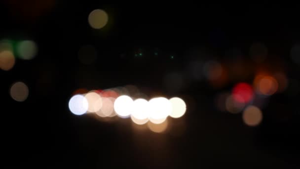 Bela bokeh brilhante em fundo escuro embaçado à noite. O brilho bokeh colorido redondo das luzes do carro na rua da cidade. Desfocado com desfocagem. Luzes da cidade desfocadas. Bokeh de trânsito. Abstrato — Vídeo de Stock