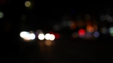 Gecenin karanlığında bulanık arkaplanda güzel, ışıltılı bir bokeh. Şehir caddesindeki araba ışıklarından yuvarlak renkli bokeh parlıyor. Bulanık yüzünden bulanık. Odaklanmamış şehir ışıkları. Trafik sıkışıklığı. Soyut