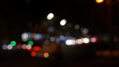 Gecenin karanlığında bulanık arkaplanda güzel, ışıltılı bir bokeh. Şehir caddesindeki araba ışıklarından yuvarlak renkli bokeh parlıyor. Bulanık yüzünden bulanık. Odaklanmamış şehir ışıkları. Trafik sıkışıklığı. Soyut