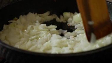 Tavada yağlı soğan kızartıyorum. Tavada soğanı ahşap spatulayla karıştır..