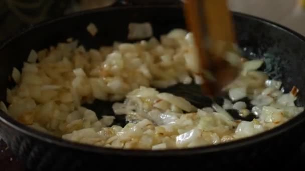 Tavada yağlı soğan kızartıyorum. Tavada soğanı ahşap spatulayla karıştır.. — Stok video
