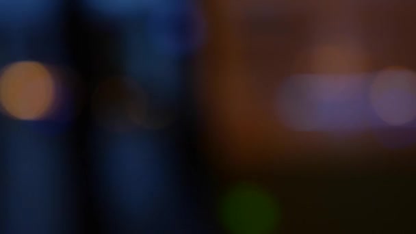 Beautiful glittering bokeh in dark blurry background at night. The round colorful bokeh shine from car lights on city street. Out of focus with blurry. Unfocused city lights. Traffic bokeh. Abstract — Stock Video