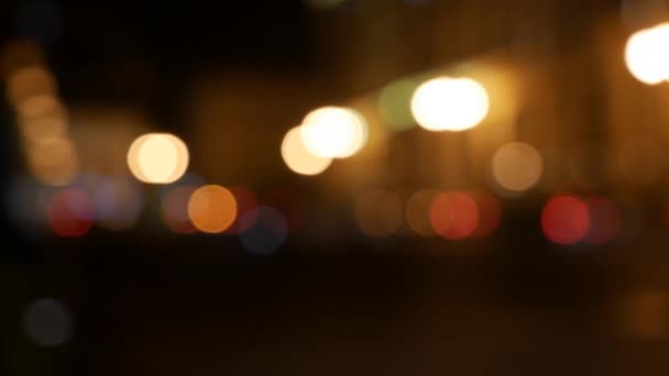 Piękny błyszczący bokeh w ciemnym rozmytym tle w nocy. Okrągły kolorowy bokeh świecą od światła samochodu na ulicy miasta. Nieostre i zamazane. Nieskoncentrowane światła miejskie. Ruch uliczny. Streszczenie — Wideo stockowe
