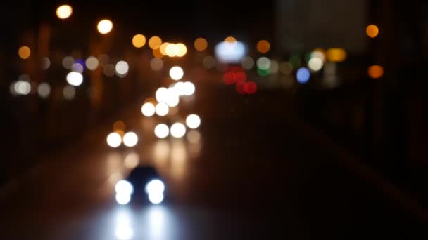 夜の闇の中で美しいきらびやかなボケ。街中の車のライトからラウンドカラフルなボケが輝きます。焦点がぼやけている。集中していない都市灯。トラフィックのボケ。概要 — ストック動画