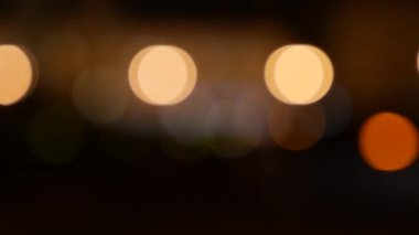 Gecenin karanlığında bulanık arkaplanda güzel, ışıltılı bir bokeh. Şehir caddesindeki araba ışıklarından yuvarlak renkli bokeh parlıyor. Bulanık yüzünden bulanık. Odaklanmamış şehir ışıkları. Trafik sıkışıklığı. Soyut