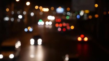 Gecenin karanlığında bulanık arkaplanda güzel, ışıltılı bir bokeh. Şehir caddesindeki araba ışıklarından yuvarlak renkli bokeh parlıyor. Bulanık yüzünden bulanık. Odaklanmamış şehir ışıkları. Trafik sıkışıklığı. Soyut