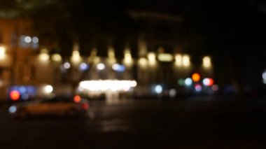 Gecenin karanlığında bulanık arkaplanda güzel, ışıltılı bir bokeh. Şehir caddesindeki araba ışıklarından yuvarlak renkli bokeh parlıyor. Bulanık yüzünden bulanık. Odaklanmamış şehir ışıkları. Trafik sıkışıklığı. Soyut