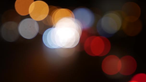 Beautiful glittering bokeh in dark blurry background at night. The round colorful bokeh shine from car lights on city street. Out of focus with blurry. Unfocused city lights. Traffic bokeh. Abstract — Stock Video