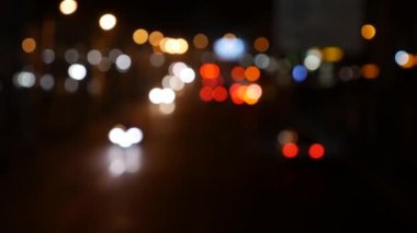 Gecenin karanlığında bulanık arkaplanda güzel, ışıltılı bir bokeh. Şehir caddesindeki araba ışıklarından yuvarlak renkli bokeh parlıyor. Bulanık yüzünden bulanık. Odaklanmamış şehir ışıkları. Trafik sıkışıklığı. Soyut