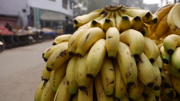 Stapels gerijpte bananen op de straatmarkt. Verkopen van gele bananen op de fruitmarkt. Aziatische markt. — Stockvideo