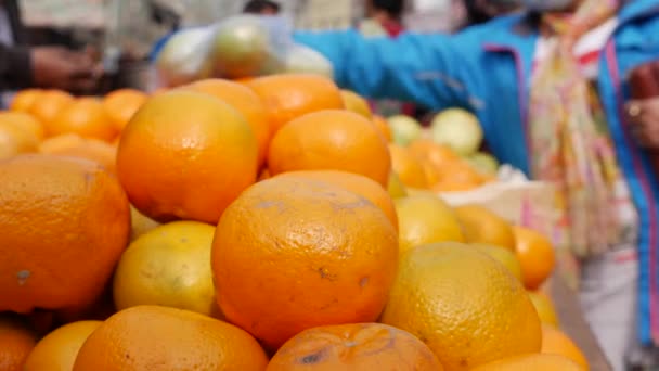 日中はストリートフード市場の棚に新鮮なジューシーなオレンジ。新鮮で有機的な果物を買うお客様. — ストック動画