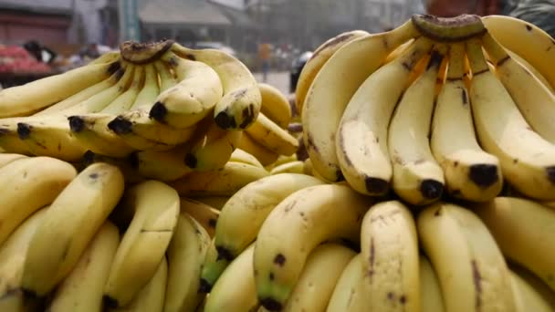 Kupa dojrzałych bananów na targu. Sprzedam żółte banany na targu owocowym. Rynek azjatycki. — Wideo stockowe