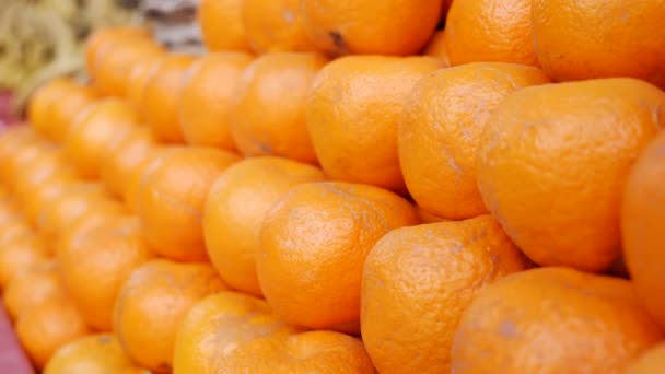 Čerstvé šťavnaté pomeranče na poličce pouličního trhu s potravinami během dne. Zákazníci nakupující čerstvé a organické ovoce. Royalty Free Stock Video