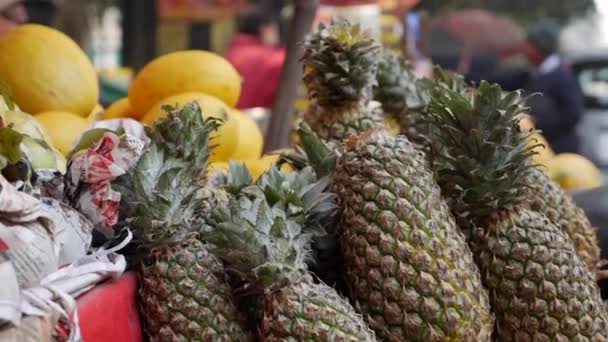 Свежие сочные ананасы на полке уличного продовольственного рынка. Покупатели свежих и органических фруктов. Стоковый Видеоролик