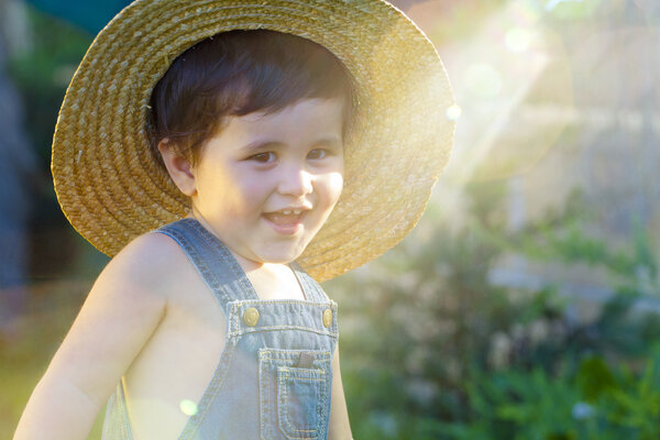little baby boy gardener smiling playful with sunburst