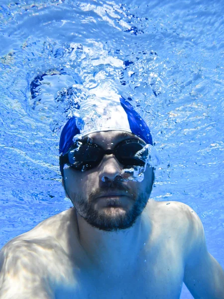 Homme nageant avec des lunettes sous l'eau dans la piscine — Photo