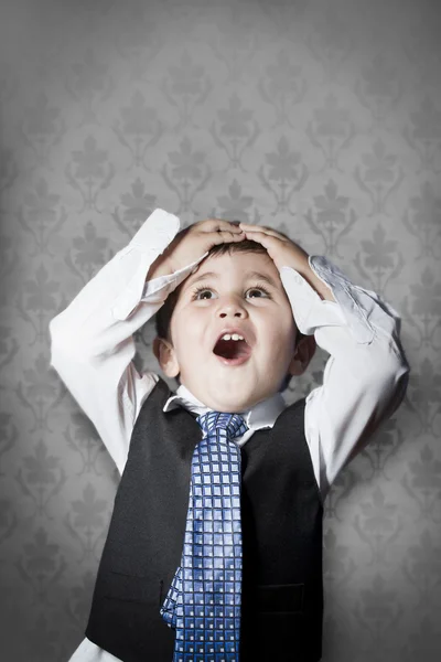 Child dressed like businessman with hands on head and face of su — Stock Photo, Image