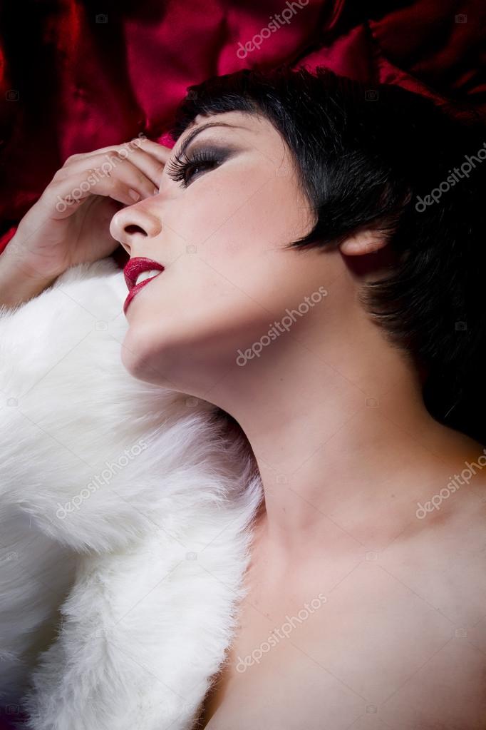 Seminude Beautiful Short Haired Brunette Woman Lying On Red Silk Stock