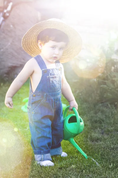 Little baby gardener concentrate in his work under sunburst — Stock Photo, Image