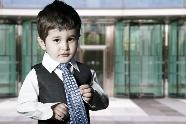 Παιδί ντυμένος επιχειρηματίας χαμογελά μπροστά από το κτίριο — Φωτογραφία Αρχείου