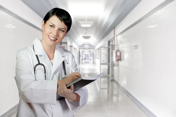 Brunetka kobiece kobieta lekarz dyżurny w szpitalu biały korytarz, dr — Zdjęcie stockowe