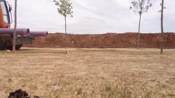 Tractor moviendo tuberías en el sitio de construcción — Vídeos de Stock