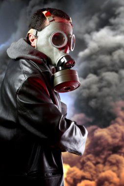 Silahlı adamın patlama arka plan üzerinde gaz maskesi