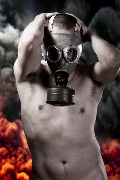 Nude man with gas mask over explosion background — Stock Photo, Image