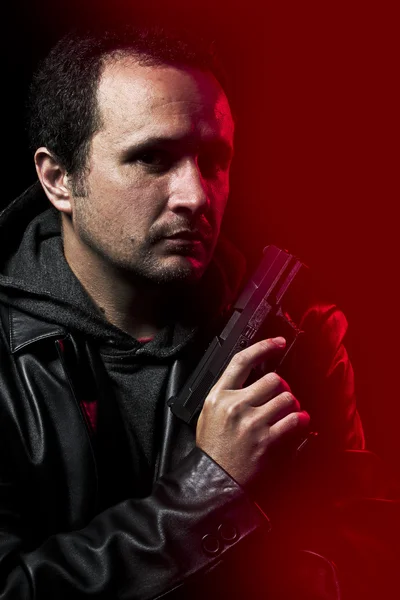 Robber with gun over red background — Stock Photo, Image