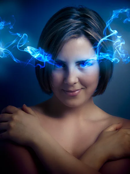 Beautiful young woman with blue eyes, blue smoke coming out of h — Stock Photo, Image