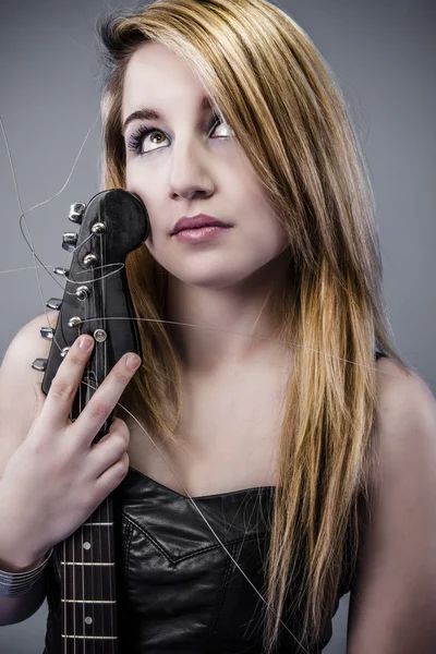 Sexy young blonde dressed in black leather holding black electri — Stock Photo, Image