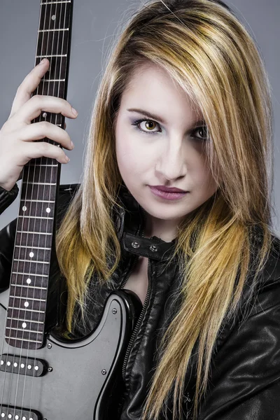 Sexy young blonde dressed in black leather holding black electri — Stock Photo, Image