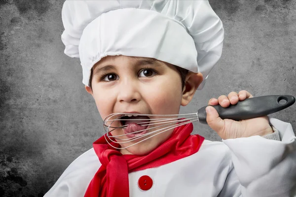 A little boy cook in uniform over vintage background — Stock Photo, Image