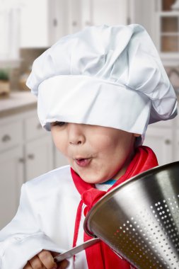 Funny boy dressed in chef with pasta drainer clipart