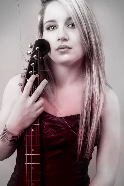 Beautiful young blond woman with electric guitar and looking tee — Stock Photo, Image