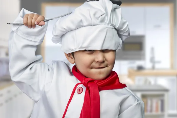 Drôle enfant habillé comme un cuisinier avec une casserole frapper la tête — Photo