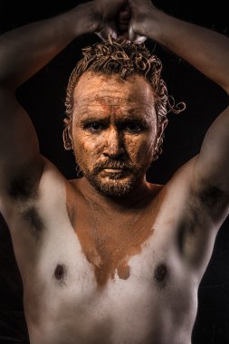 onun yüzü olan çıplak bir adam kil kaplı